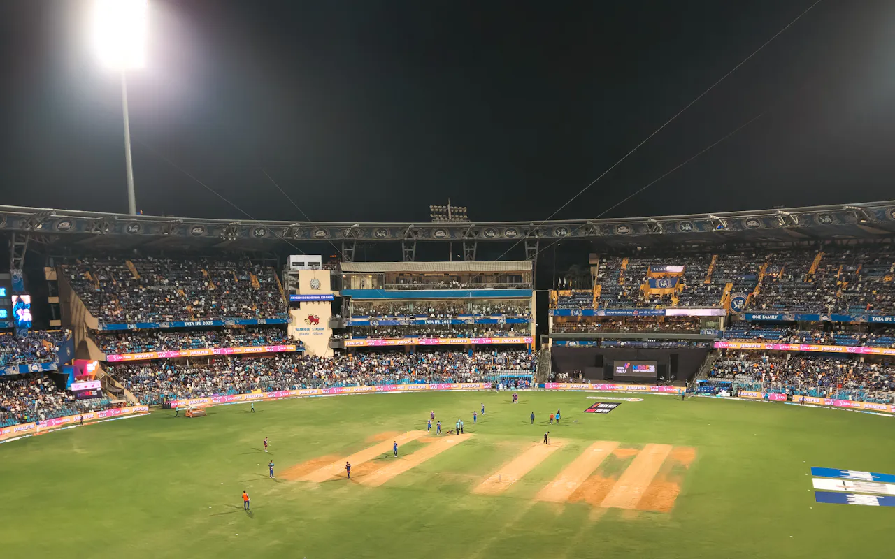 Cricket match under stadium floodlights at night